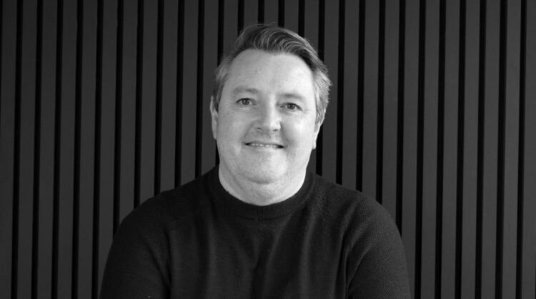 A white male architect portrait in front of a black wall. Associate Director Mark Massey